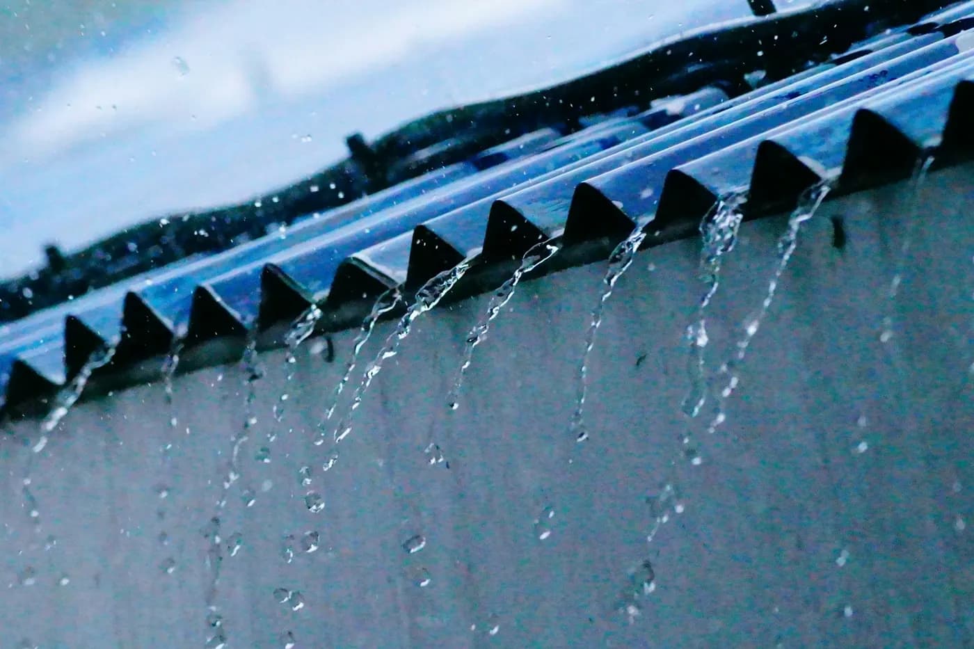 Rainwater running off the ribs of a metal roof panel