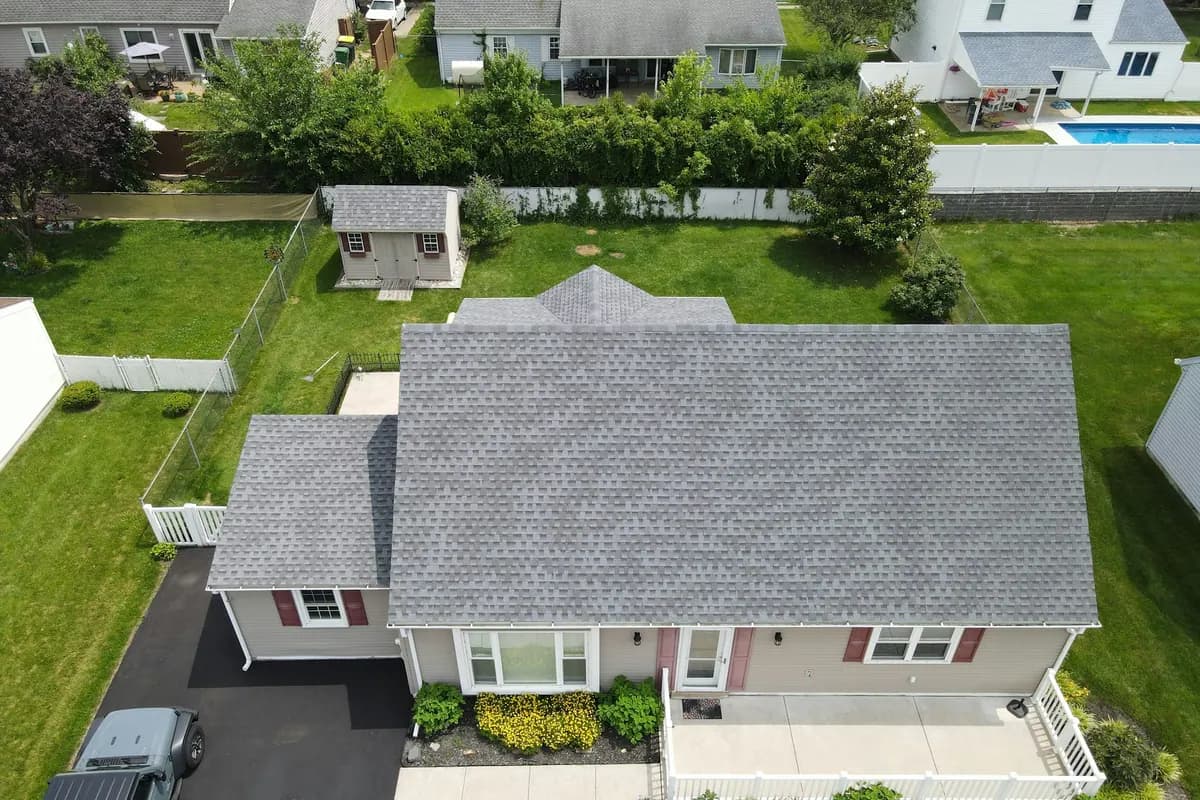 An aerial view of a house with a grey asphalt shingle roof