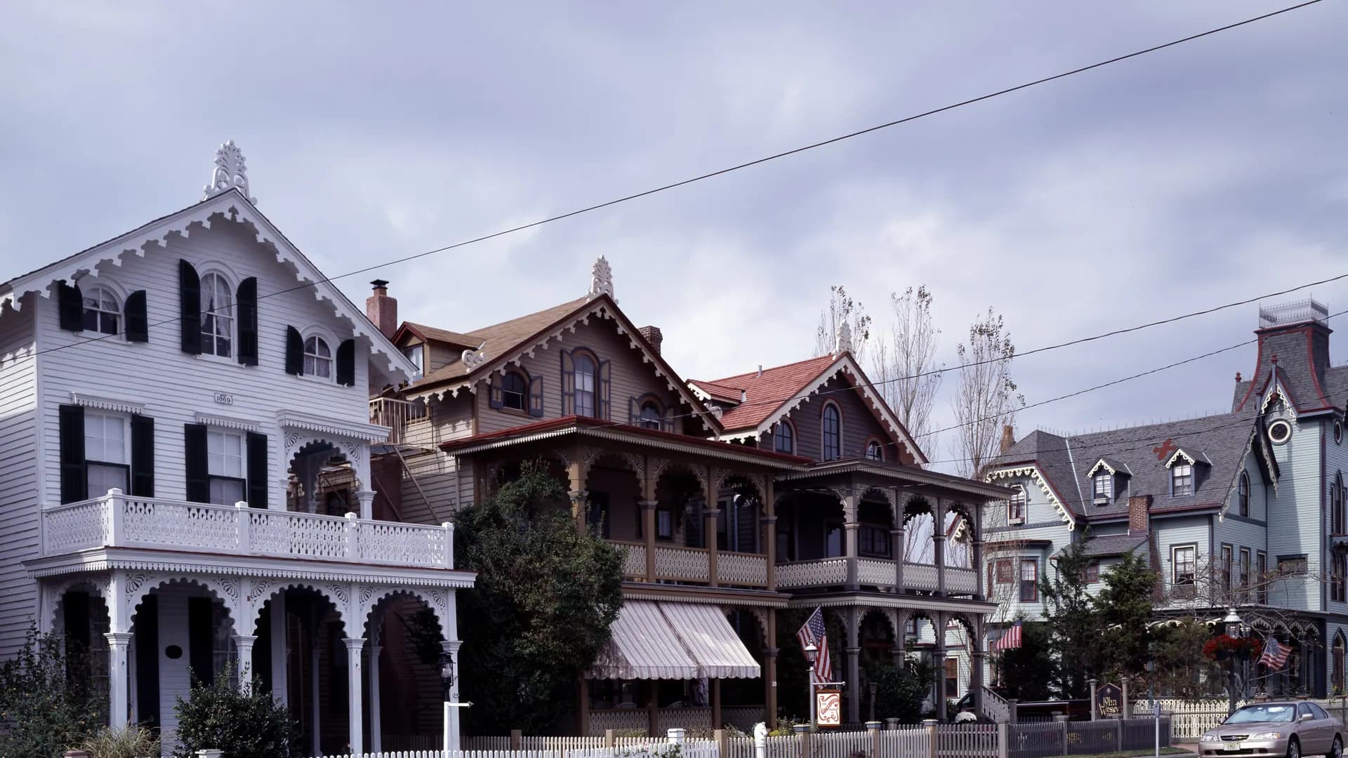 A row of Victorian cottages with porches, dormers and steep gables in Cape May, New Jersey